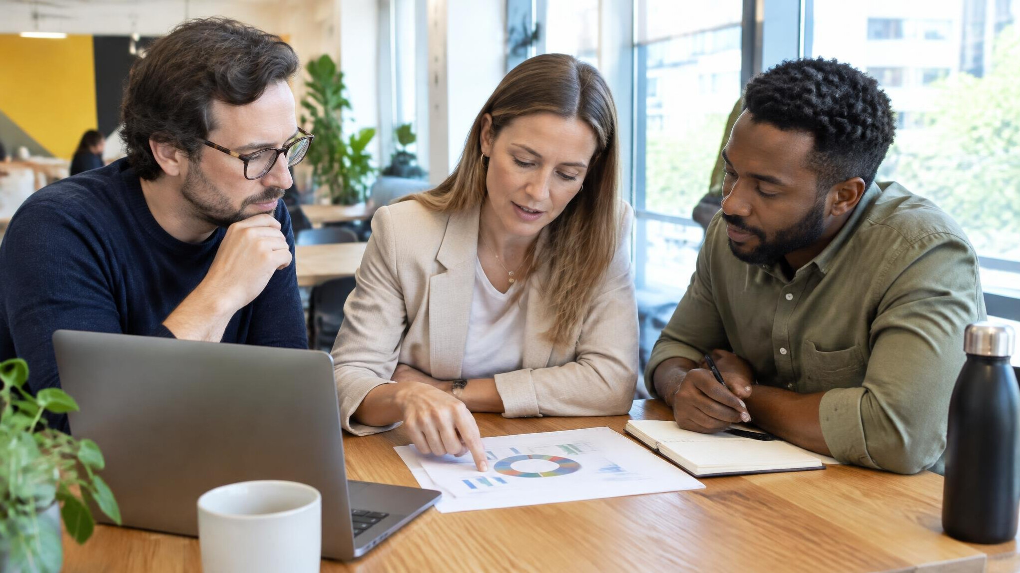 Small group of professionals having a discussion around a table with notes